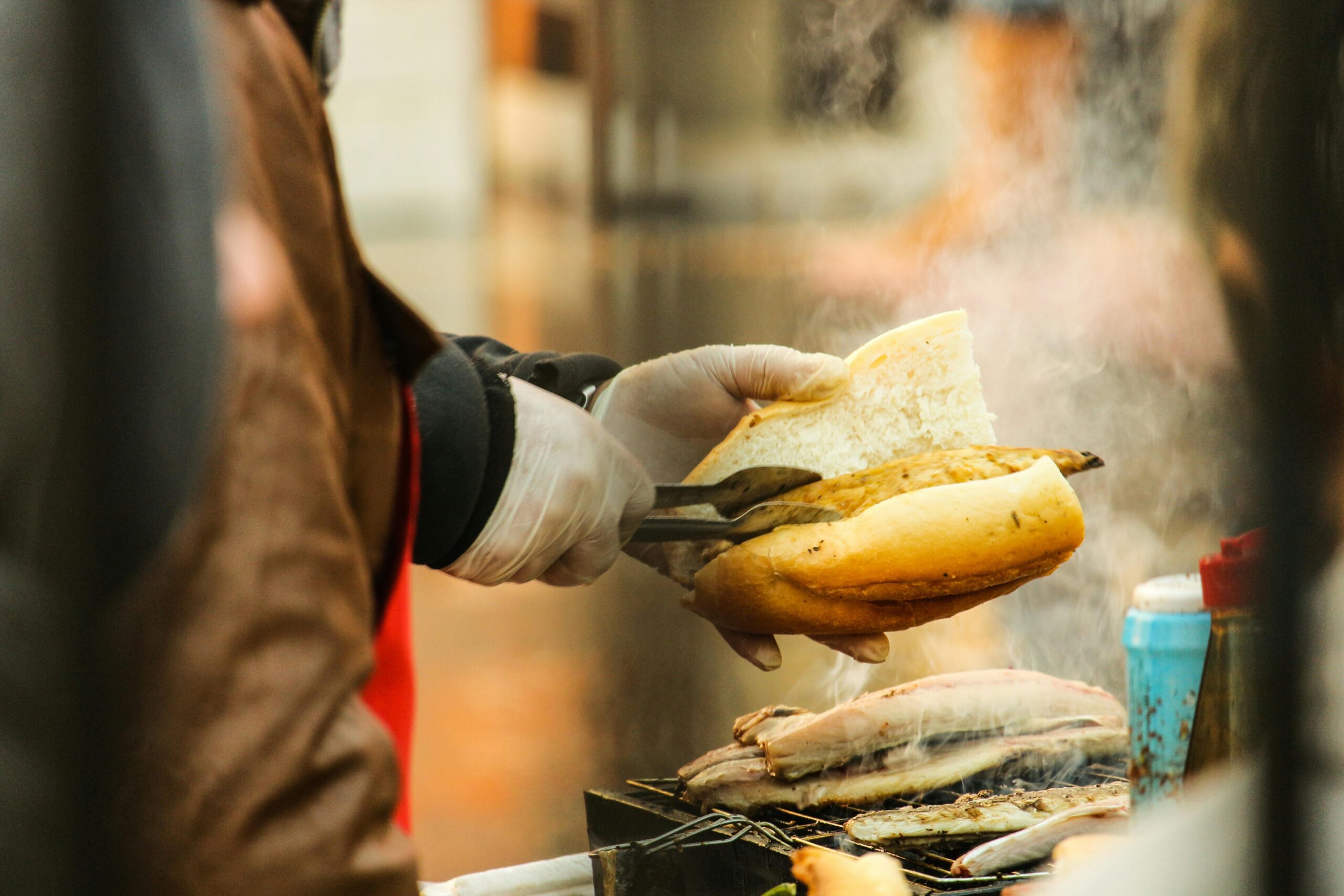 Grillen! Die besten Tipps für Grillvorbereitungen und -techniken 10 Person, Die Gegrilltes Essen In Geschnittenes Brot Legt